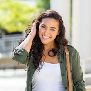 smiling woman tucking hair behind ear